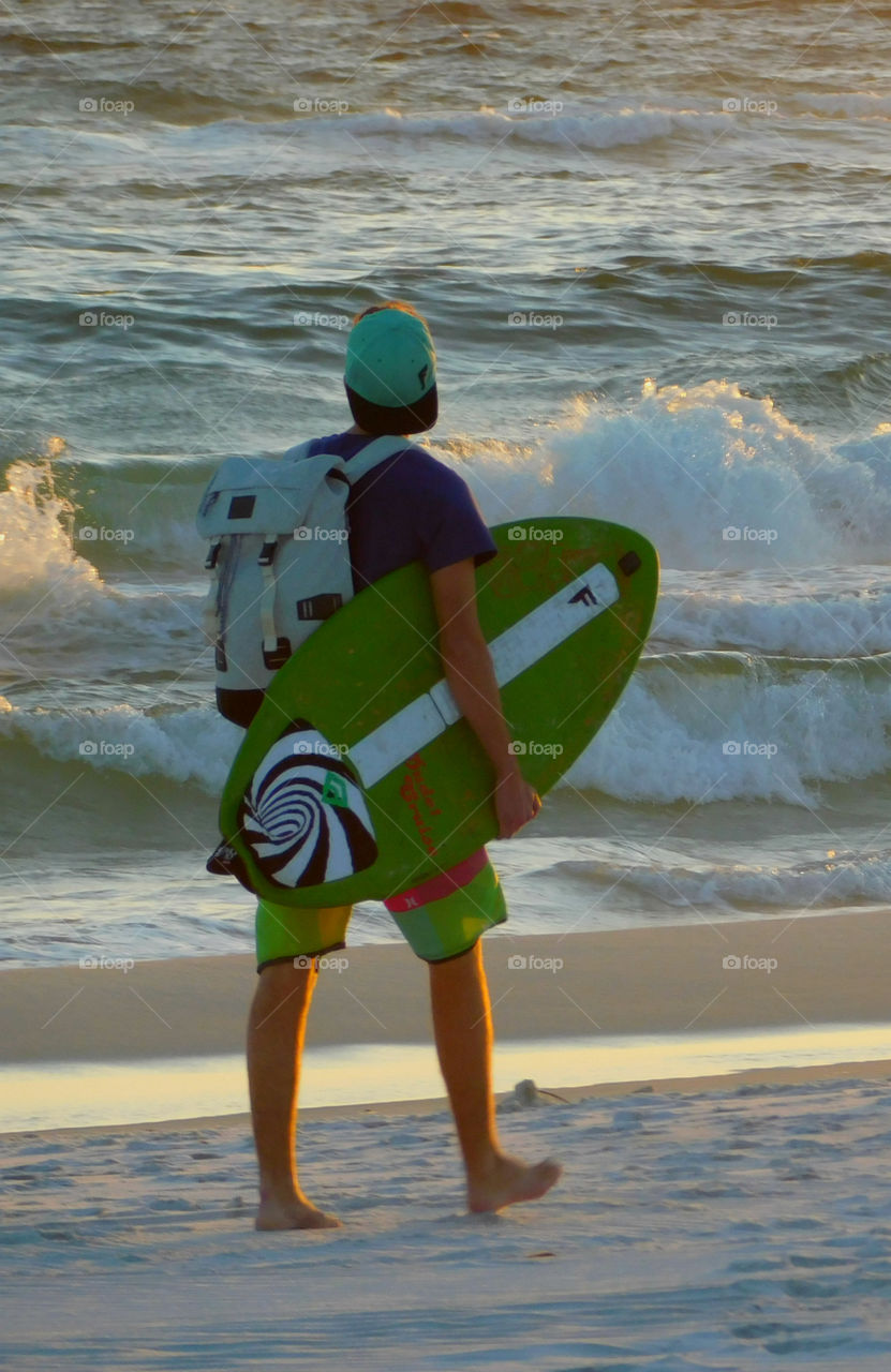 A Surfer looks over the waves churning in the Gulf of Mexico to see which are the most challenging to ride and conquer!