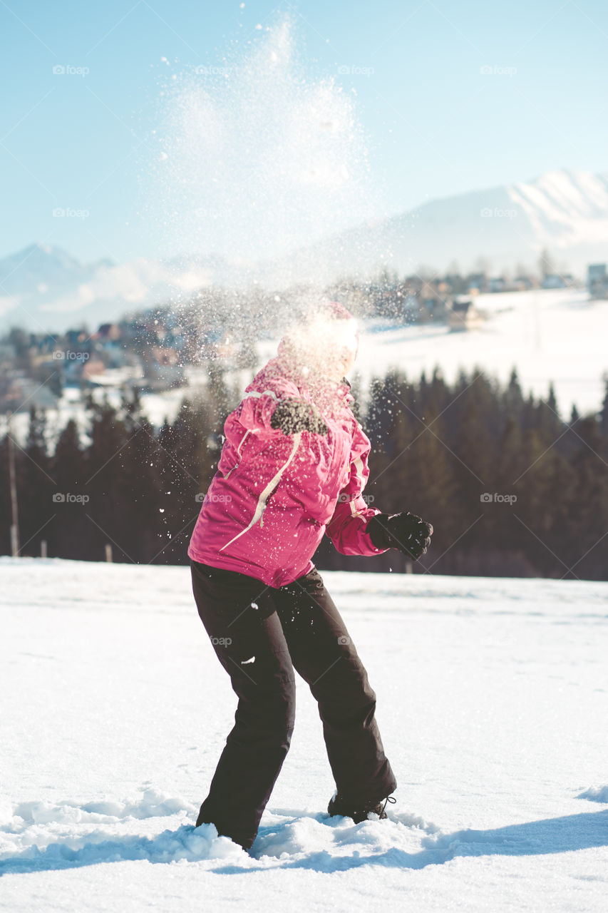 Woman throwing the snow in the air