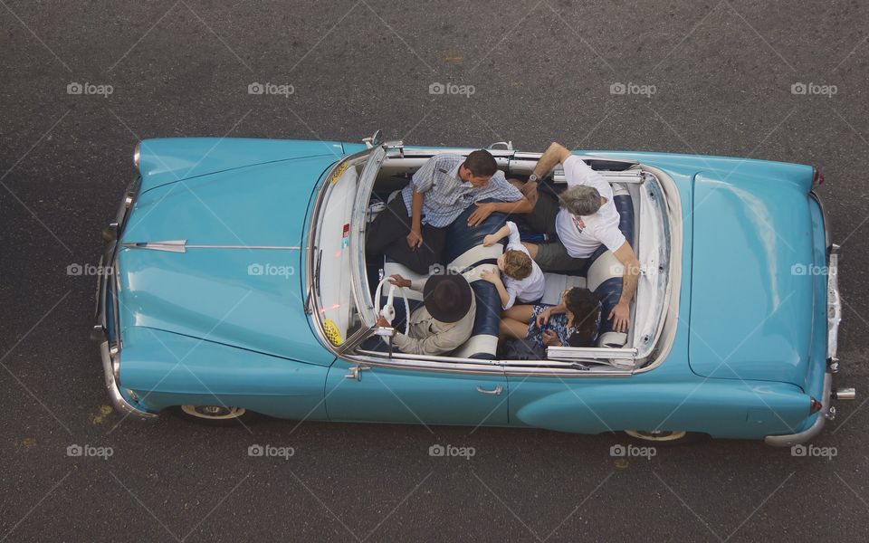A bird's eye view from a rooftop of a classic American car in Old Havana, Cuba