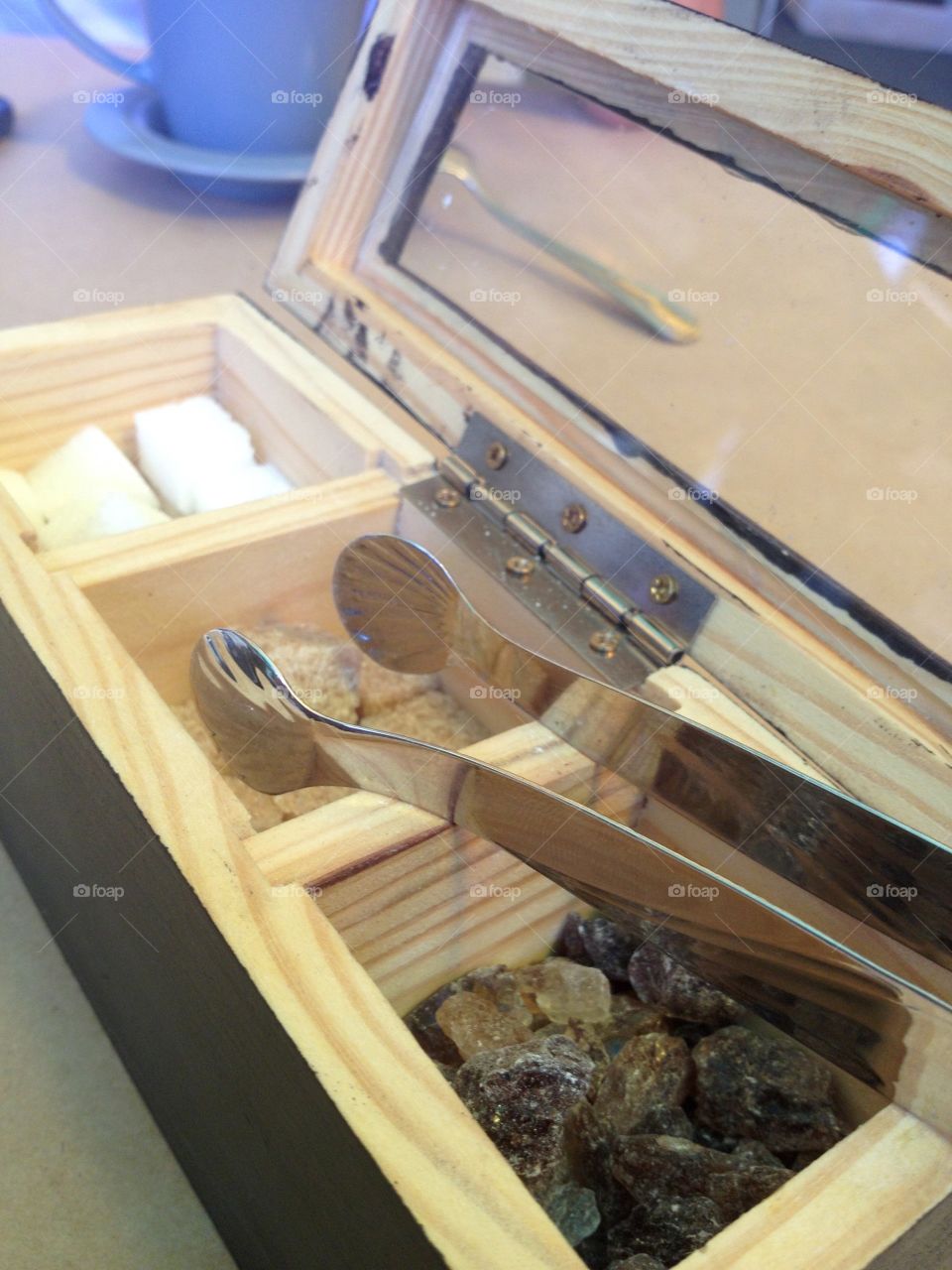 Different sugar types in a wooden box with tongues