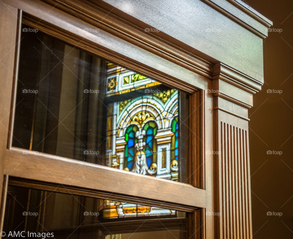 Reflection of a stained glass in a wooden door window