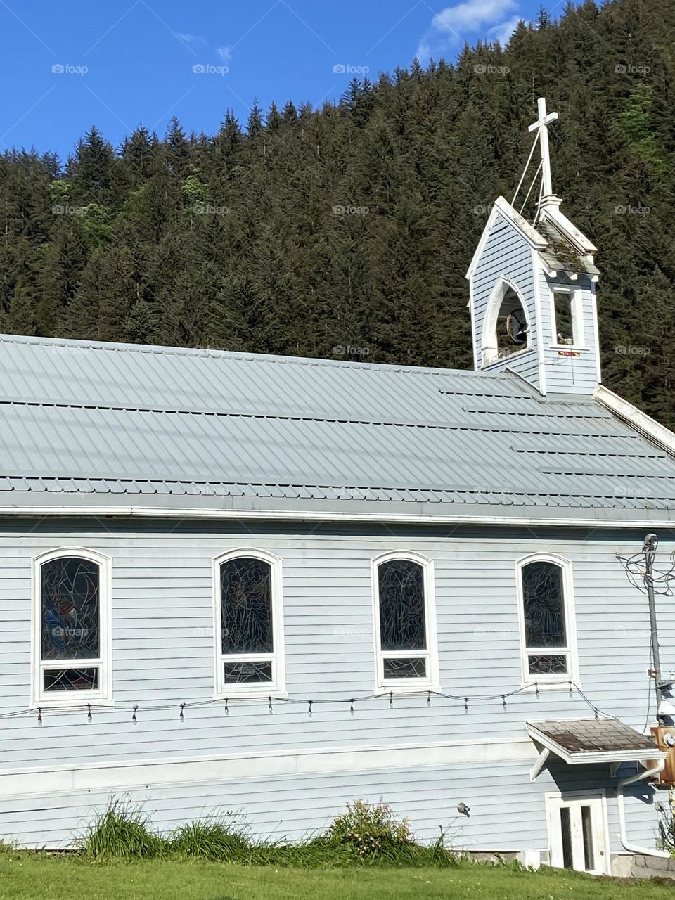 Small wooden church in Juneau, Alaska near a forest.