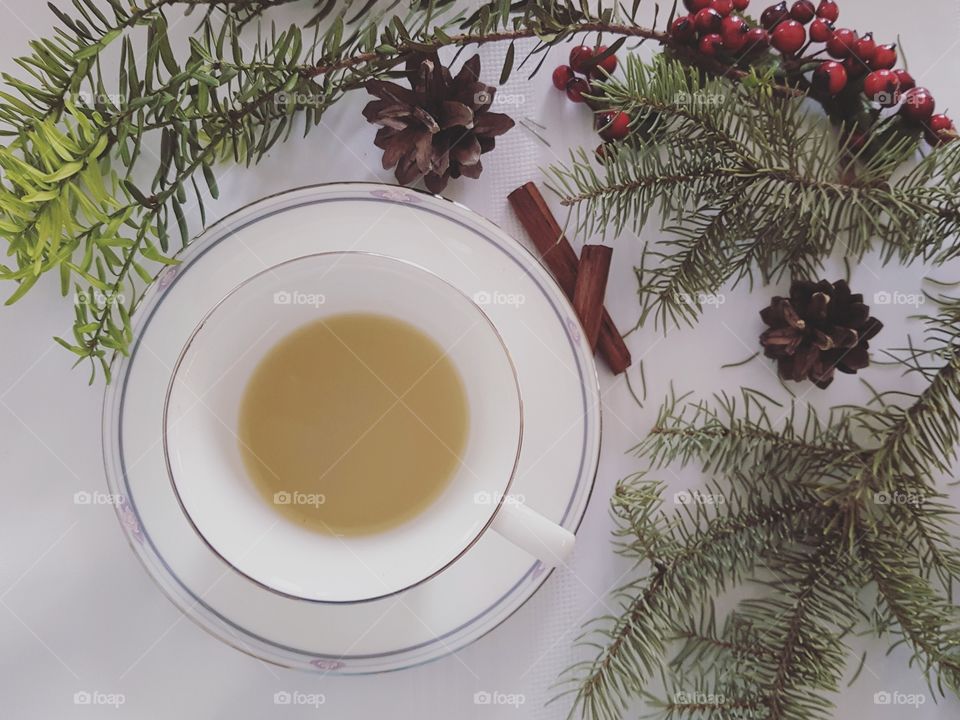 A cup of mint tea on a white table with natural decorations