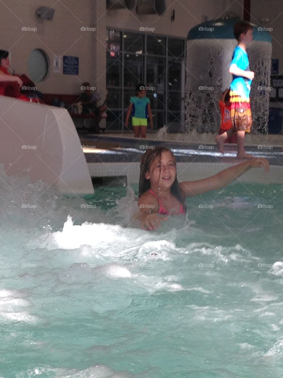 Swoosh!. Girl in pool after coming off water slide