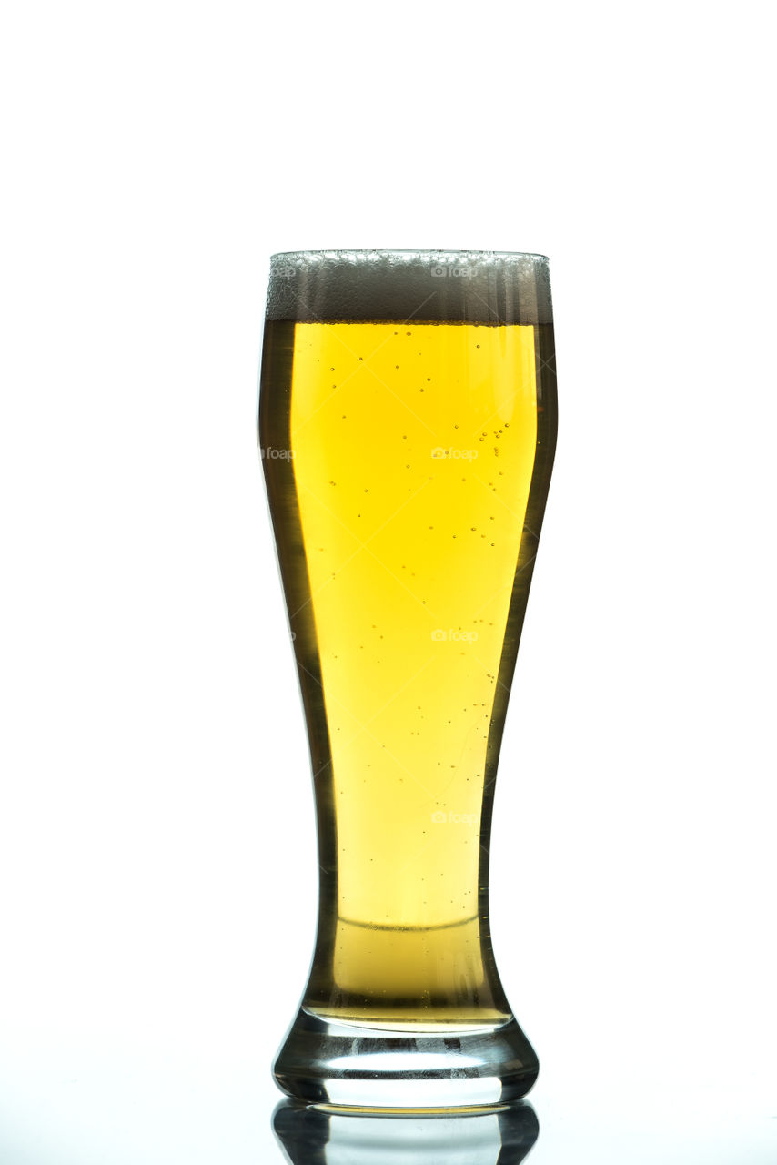 glass of golden beer isolated on white background