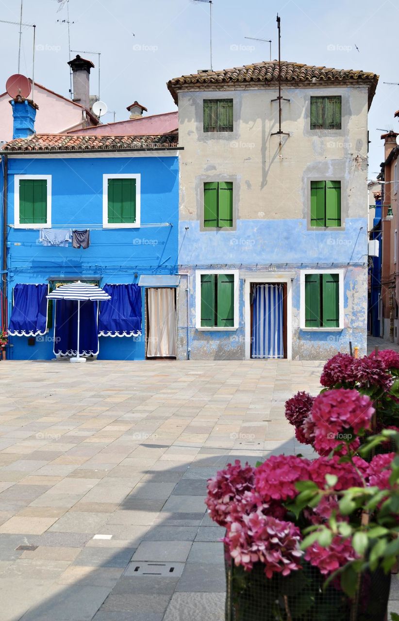 Typical colorful houses in the Venetian island of Burano; facades of buildings painted in various shades of blue.