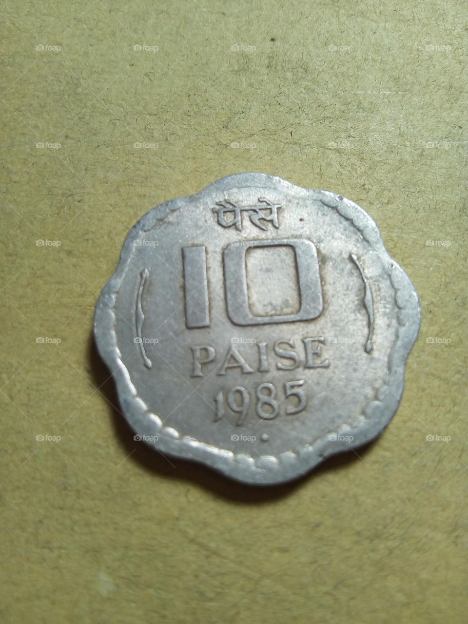 A coin of ten paise- 1/10 share of Indian Rupee issued by Government of India in 1985.