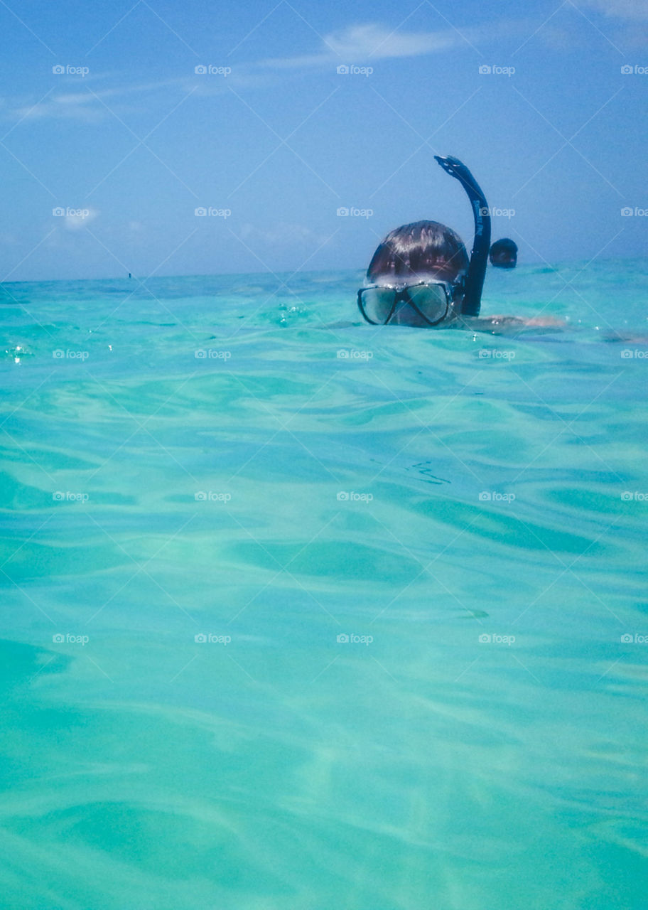 Snorkeling boy alone in the sea