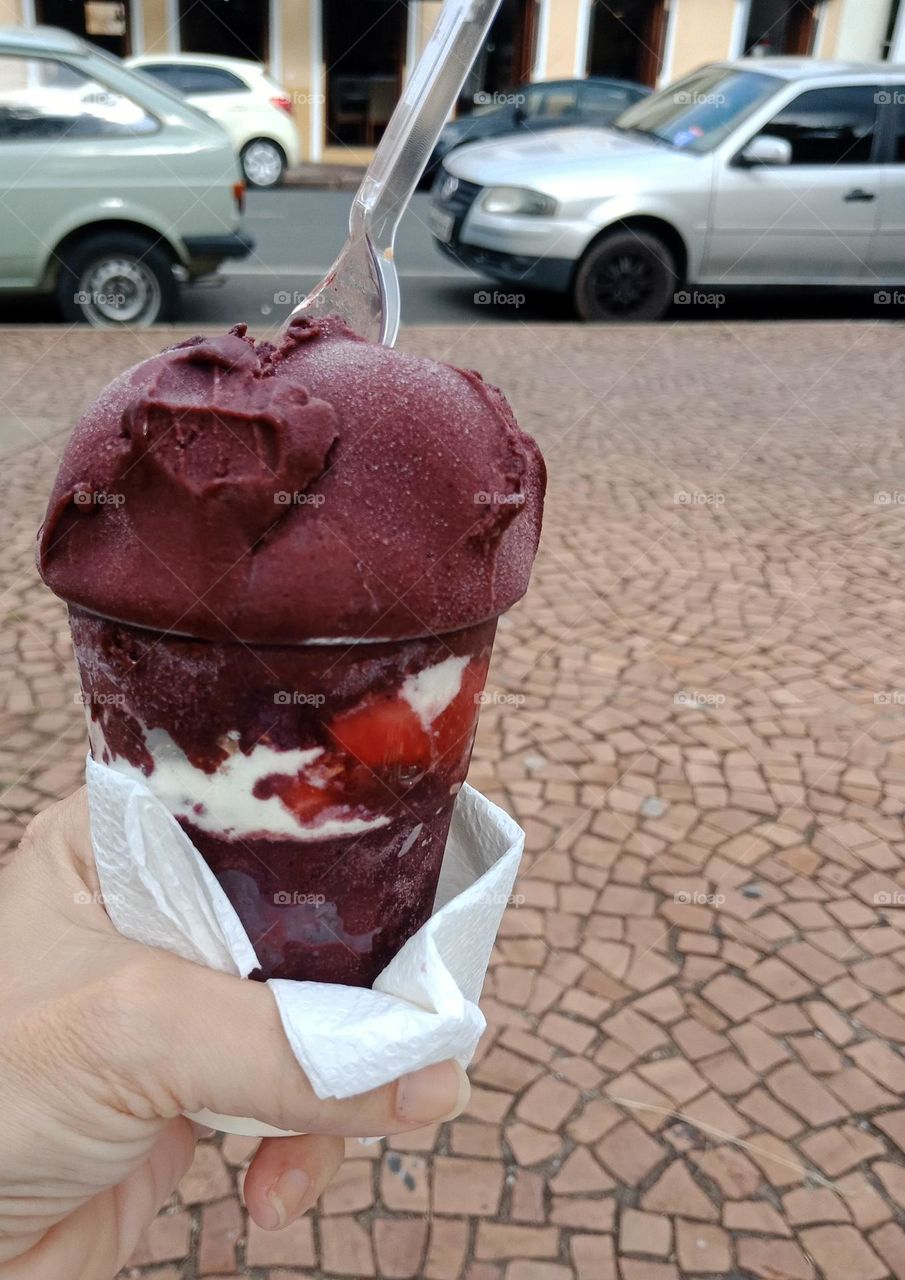 Açaí cup with strawberries and powered milk on a hot afternoon