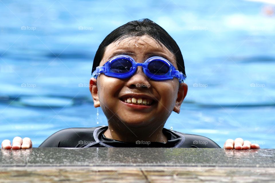 young boy with goggles in a swimming pool