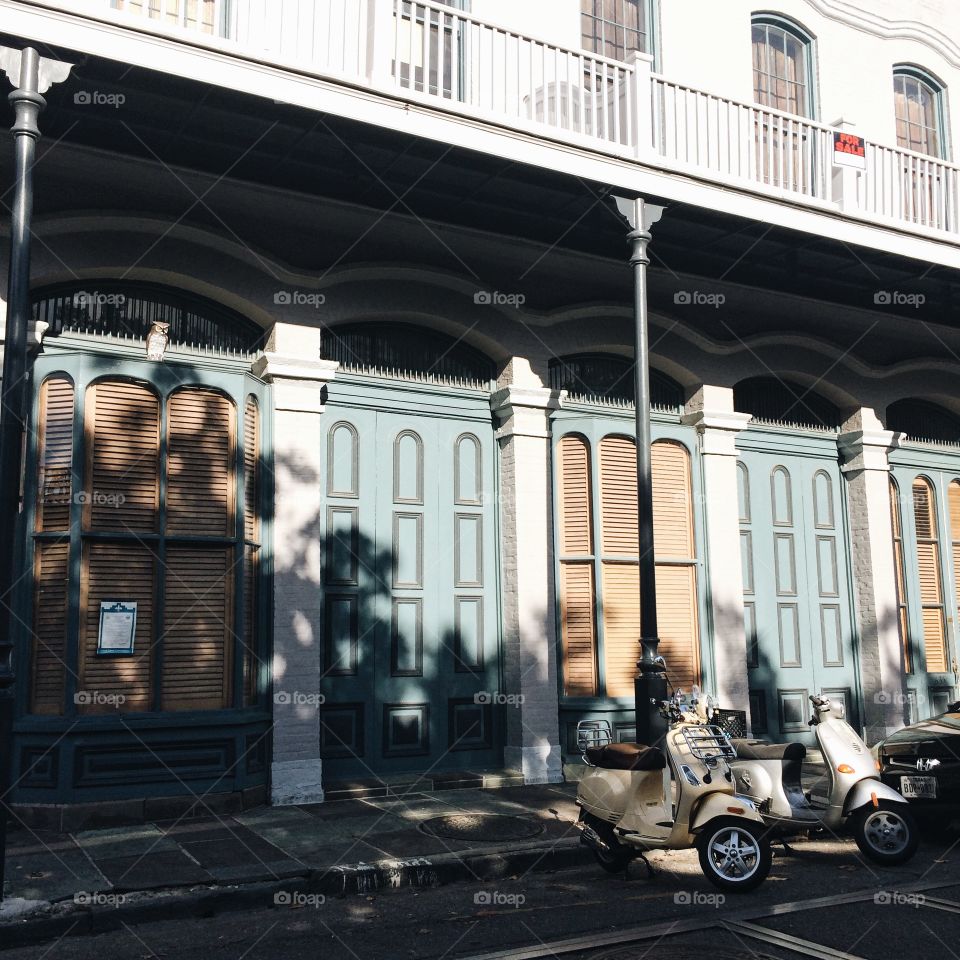 A street corner in New Orleans, matching Vespa scooters outside, and lovely robins egg doors
