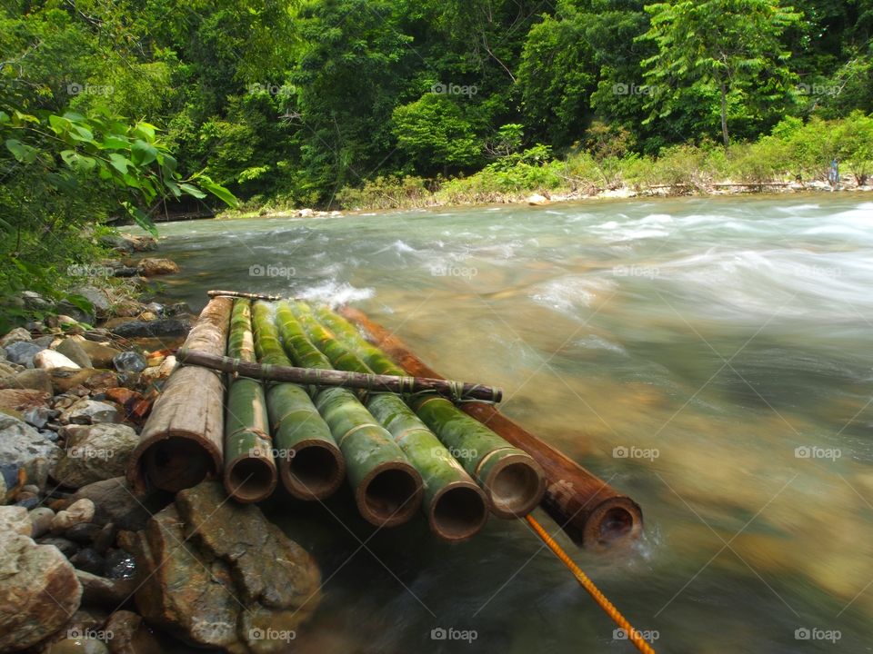 Bamboo raft tied up against the strong current