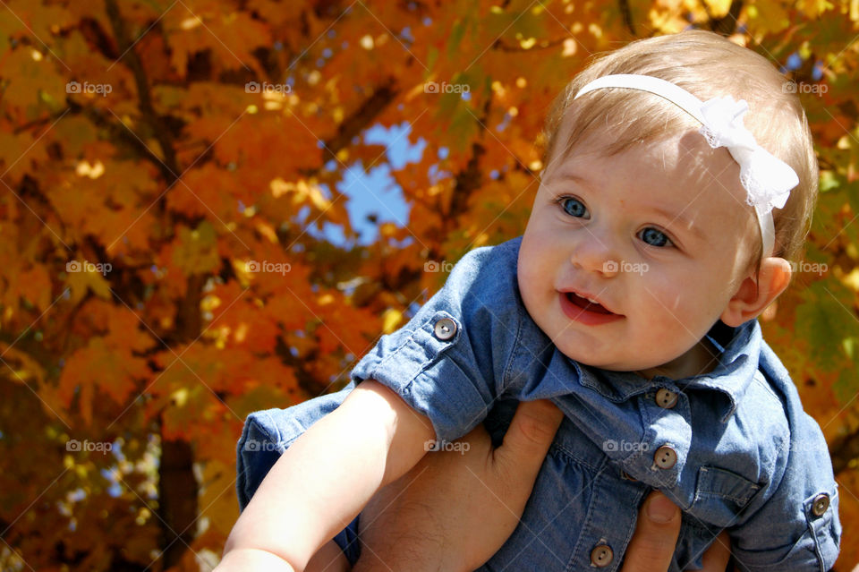 Portrait of a cute girl against autumn tree