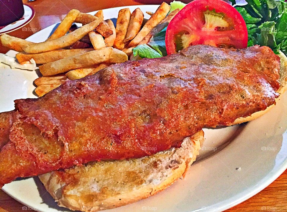 Fried Grouper sandwich with lettuce and tomato on sourdough bread with lettuce and tomato and French fries on the side! With tarter sauce on the side.