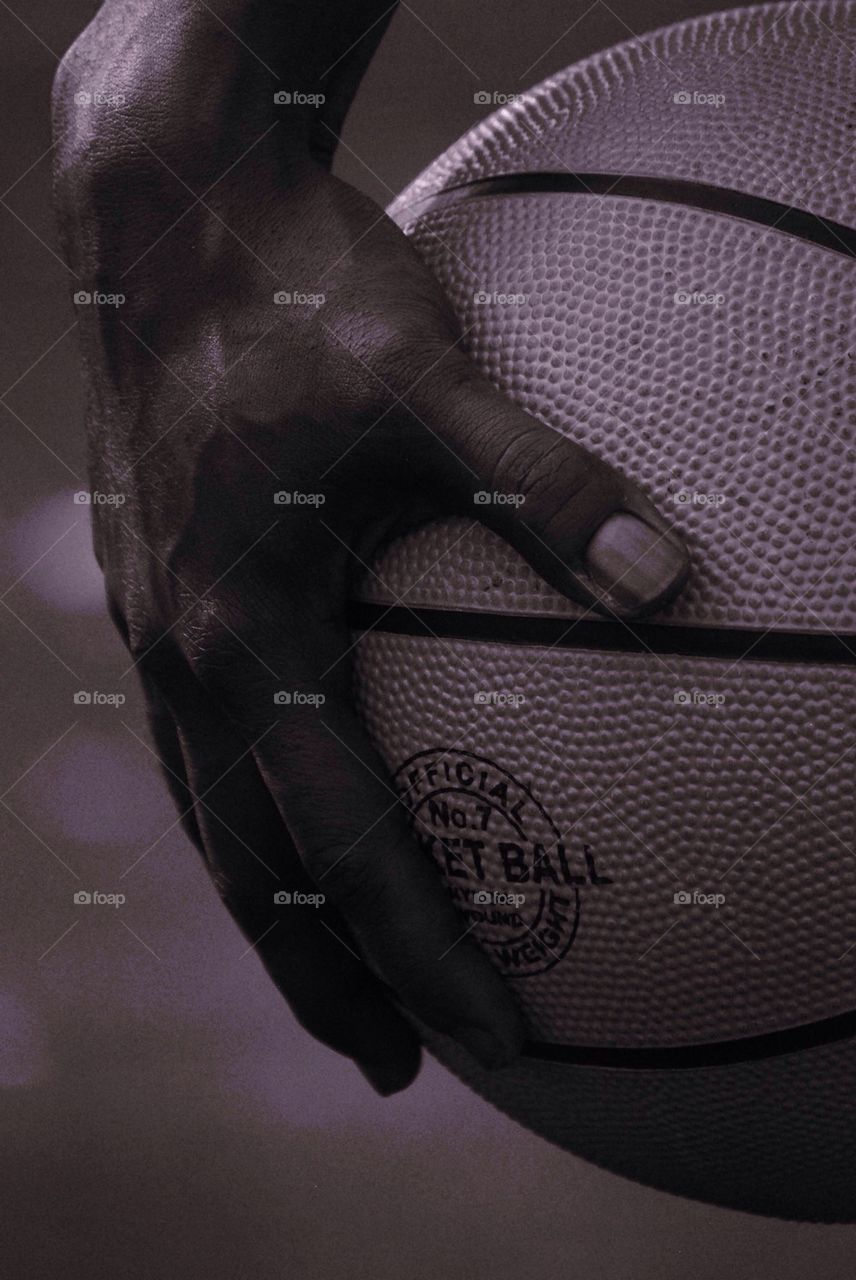 Close-up of players hand holding basket ball