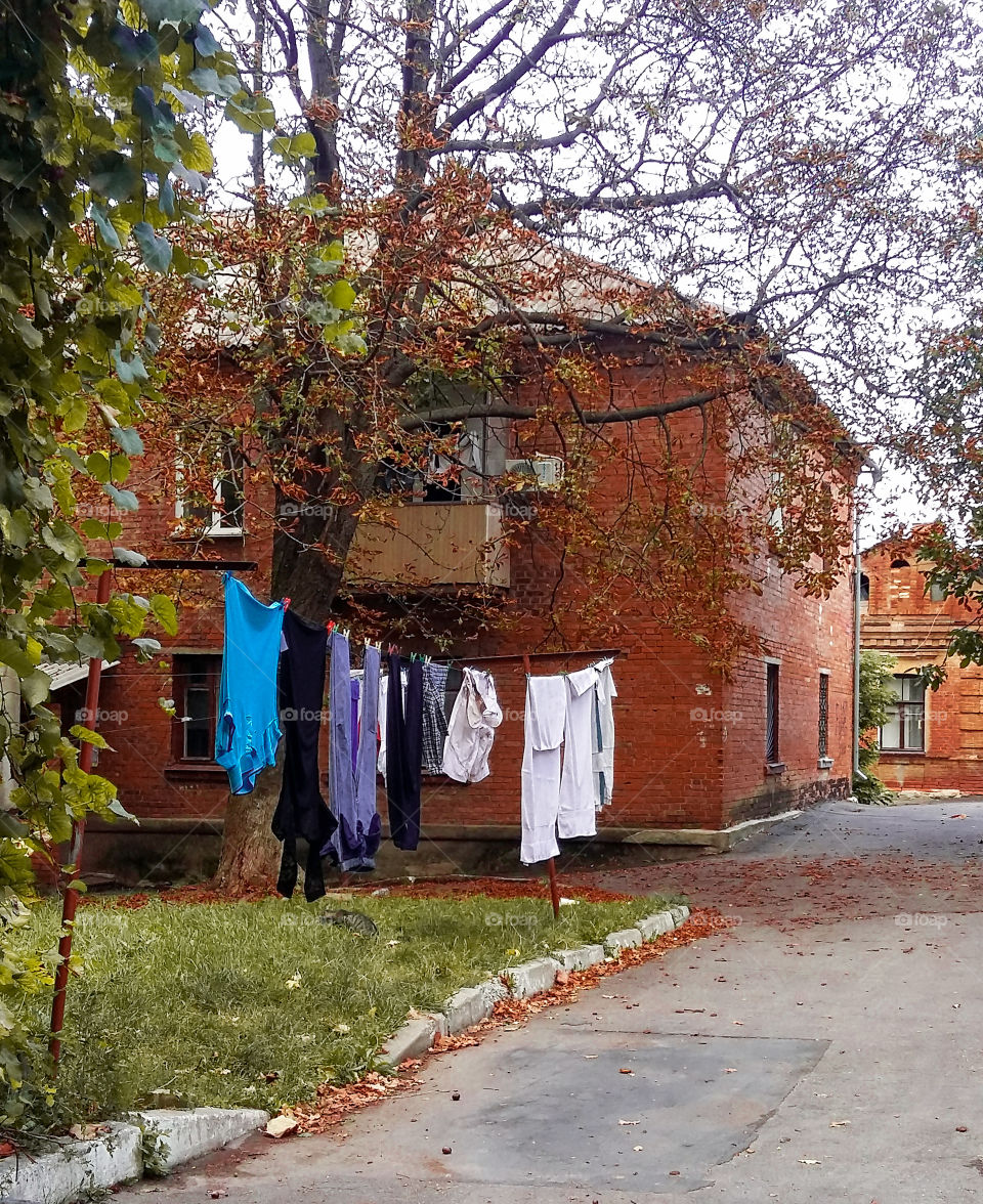 drying clothes in the street in the courtyard of a two-story house