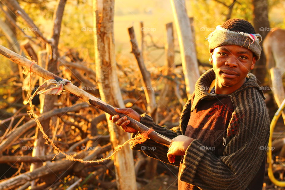 Close-up of african young man holding wooden log