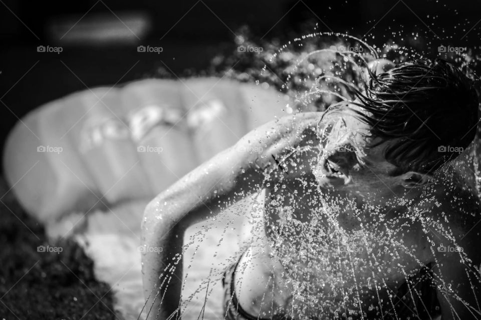 Close-up of a young man splashing water with his hairs