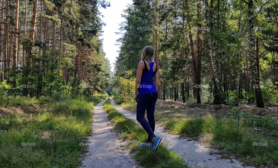 woman in running clothes on forest path