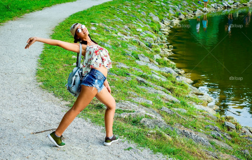 Fashion woman in eyeglasses posing near lakeshore