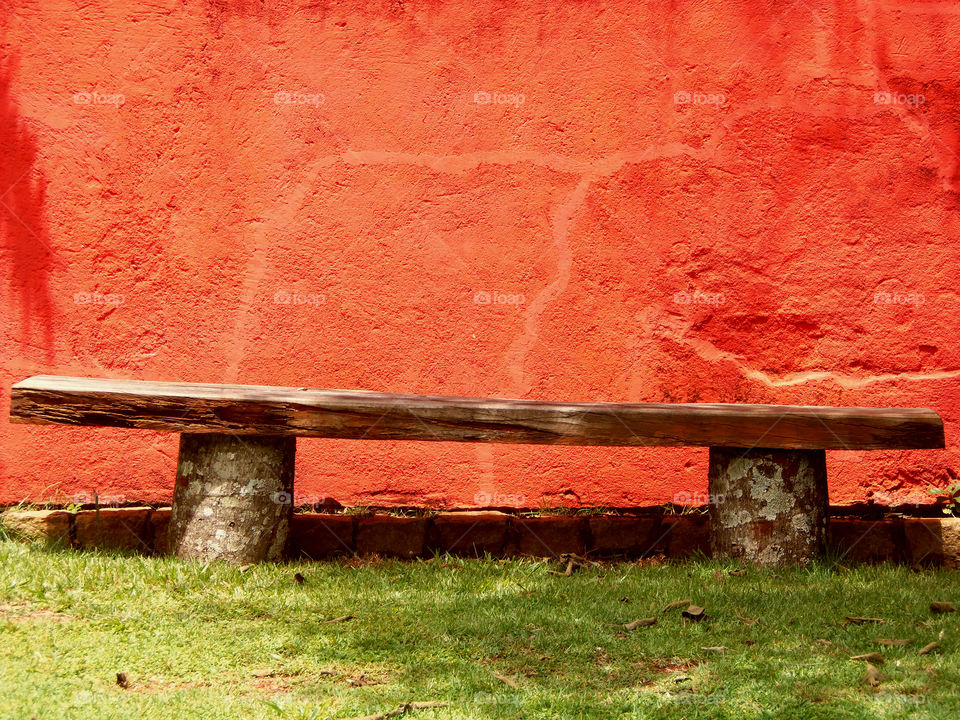 Wood bench and the red wall