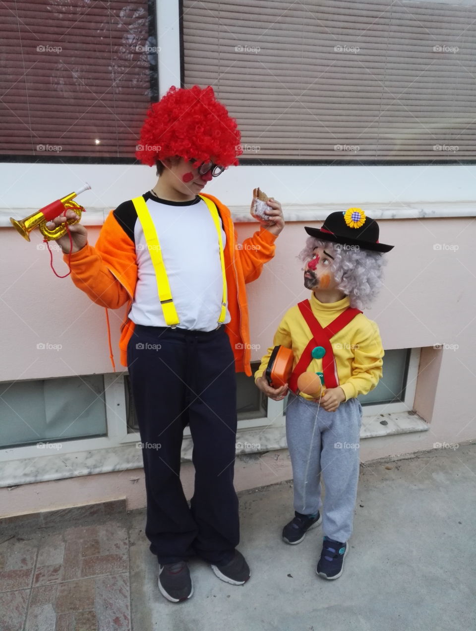 two boys in carnival costumes clown