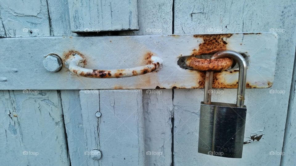 Padlock on rusty door
