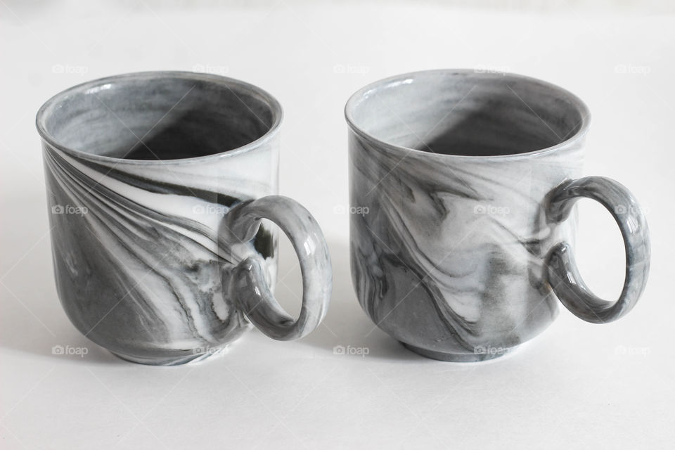 Two marble coffee cups on white background