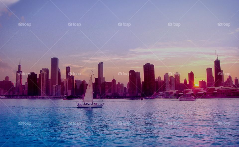Sail boat overlooking Chicago skyline at sunset 