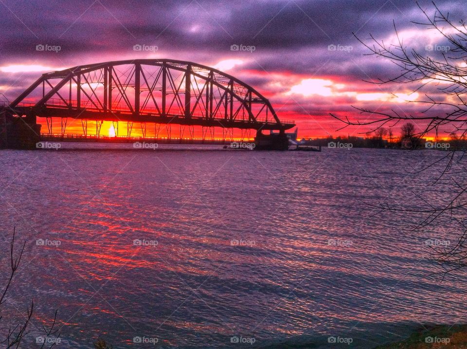 Silhouette of bridge over sea at sunset