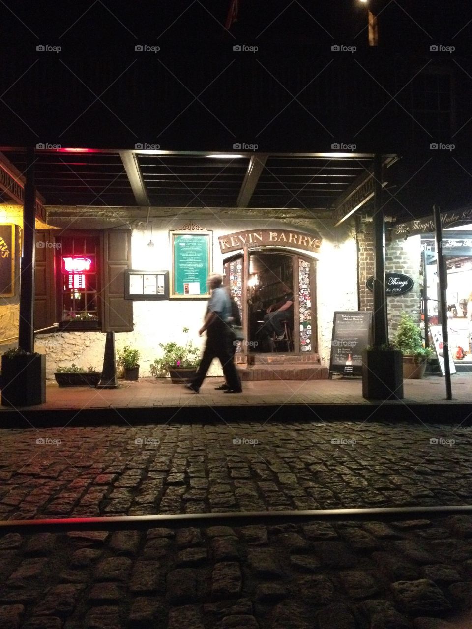A tourist walks by a pub in the historic district of Savannah Georgia
