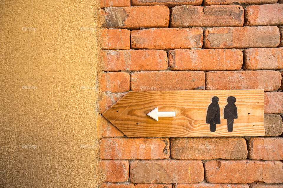 Restroom sign on the brick wall