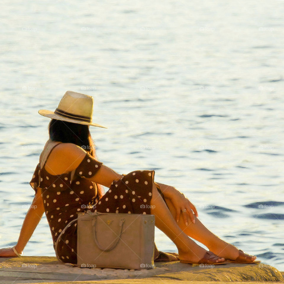 Woman enjoying golden hour at the water’s edge