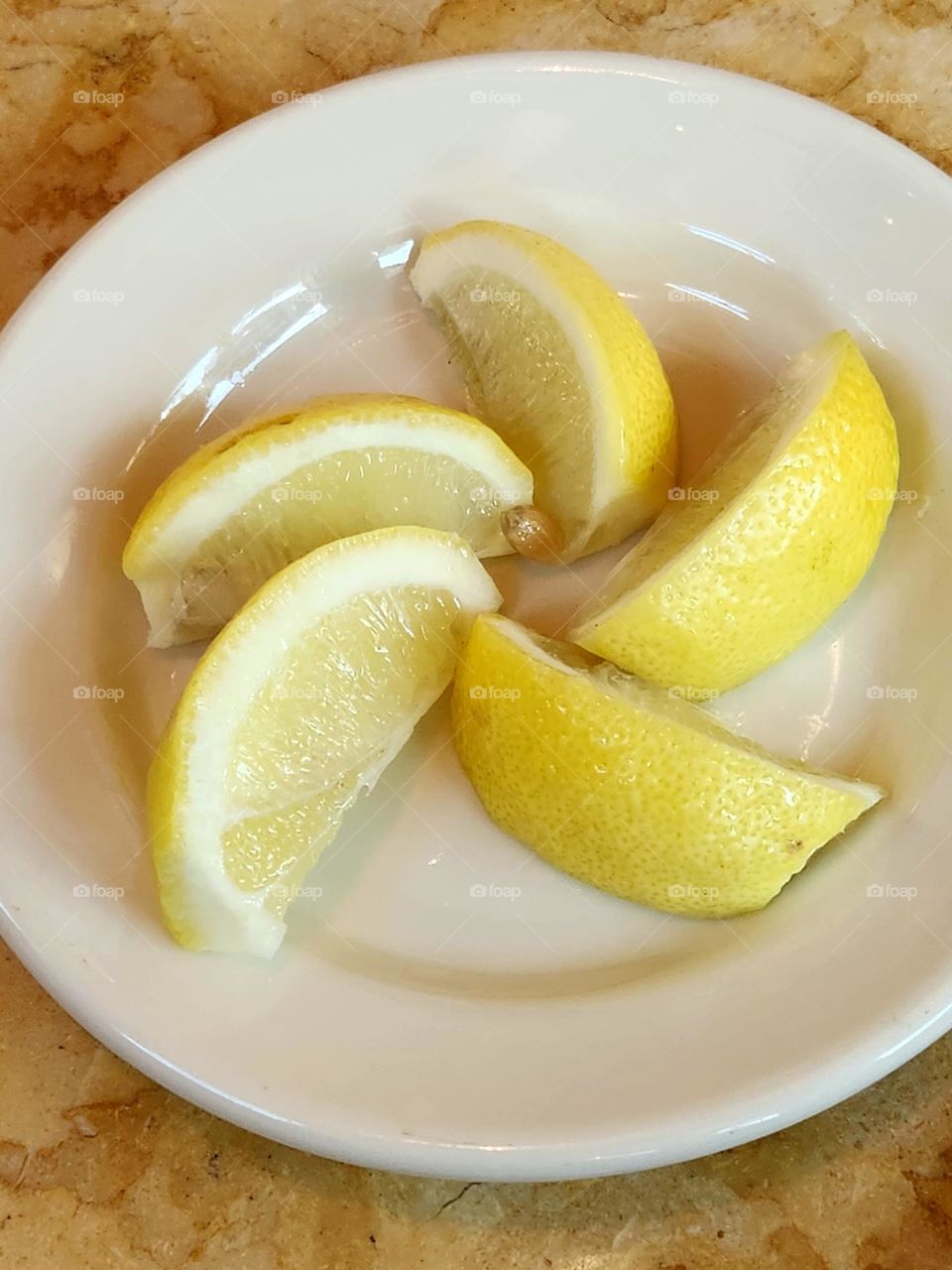 yellow lemon wedges in a pinwheel shaped pattern on a white plate in an Oregon restaurant