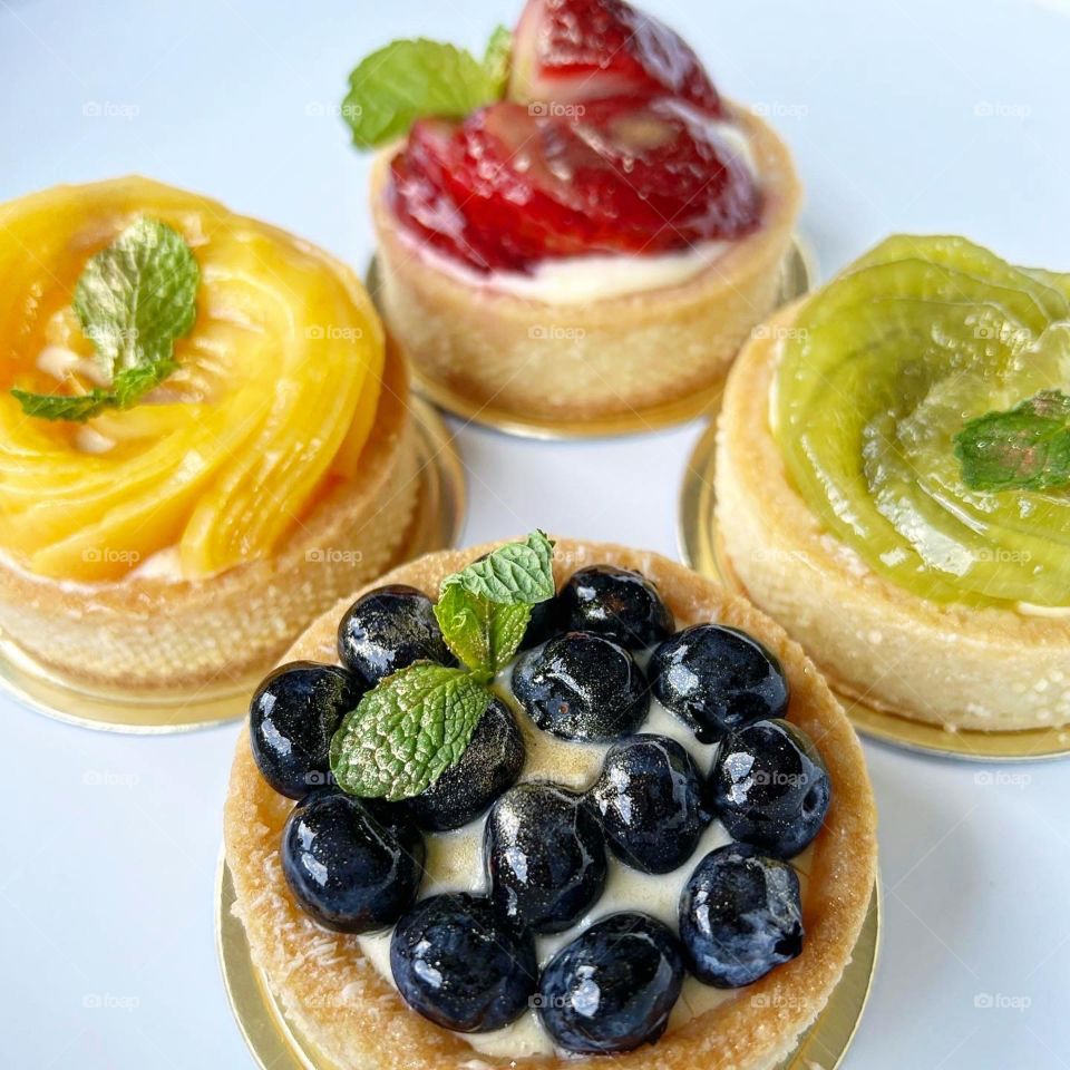 Homemade yummy colourful fruit tarts in berries and kiwi mango