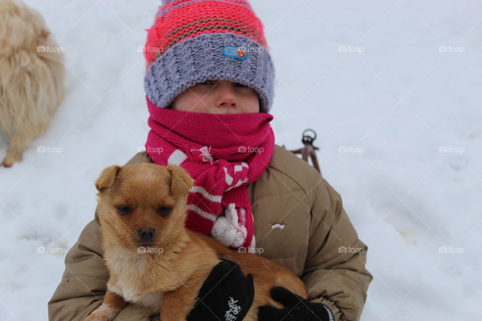 Child and dog playing in the snow