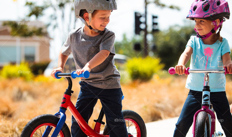 Kida riding a bike with helmets having fun