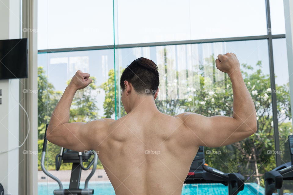 show muscles body of handsome man in the gym or fitness center, Health concept