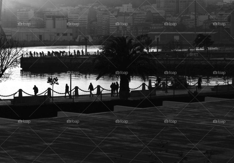 people walking and fishing in the port of Coruna, Spain