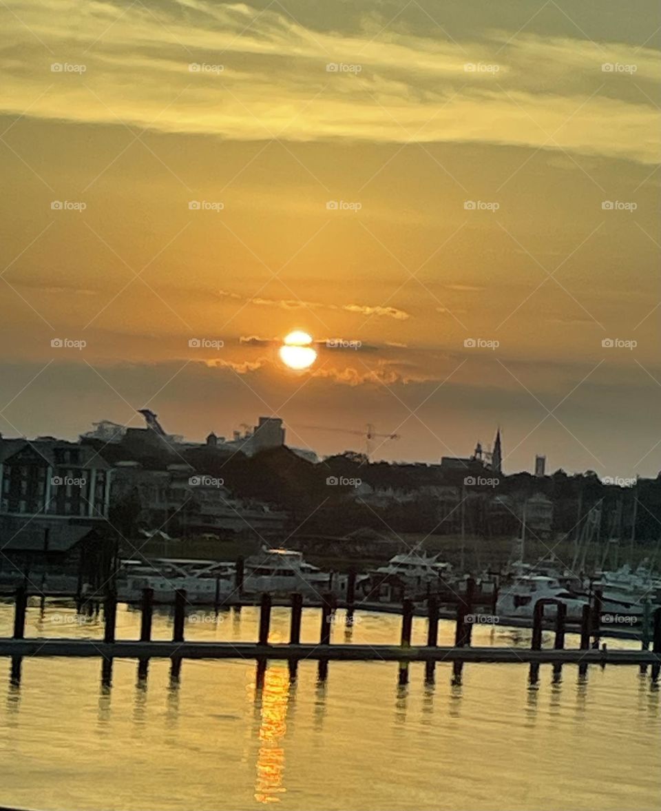 Local boats anchored in the Marina. Start of the day sky and peaceful waters. Cruise chip anchored in deeper water. 