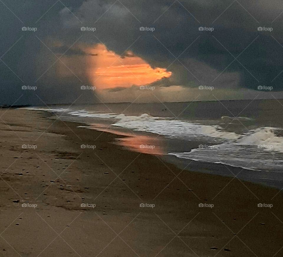 here comes the storm at sunrise on the beach