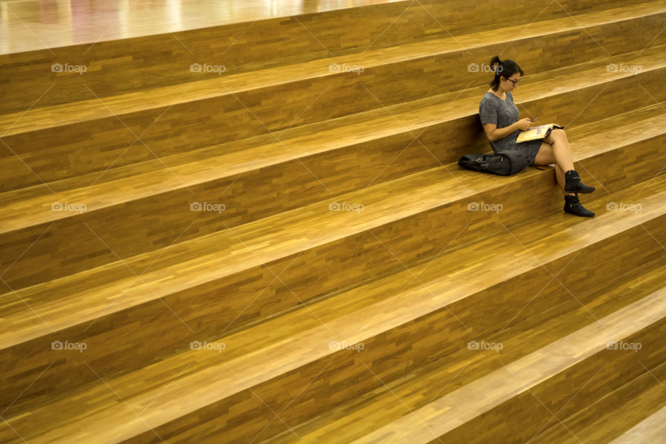 Girl reading on wooden stairs