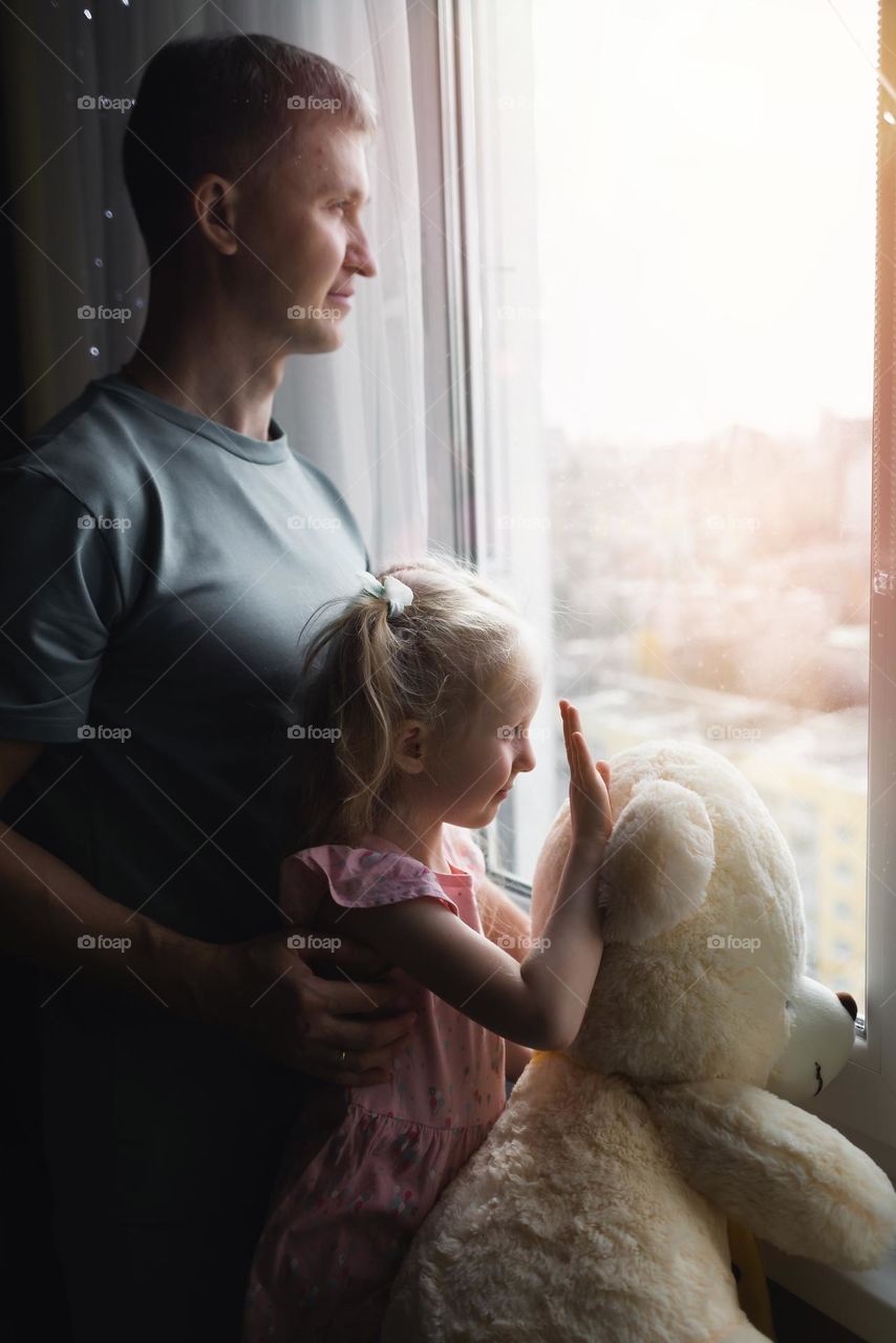 Dad and little girl looking at the window 