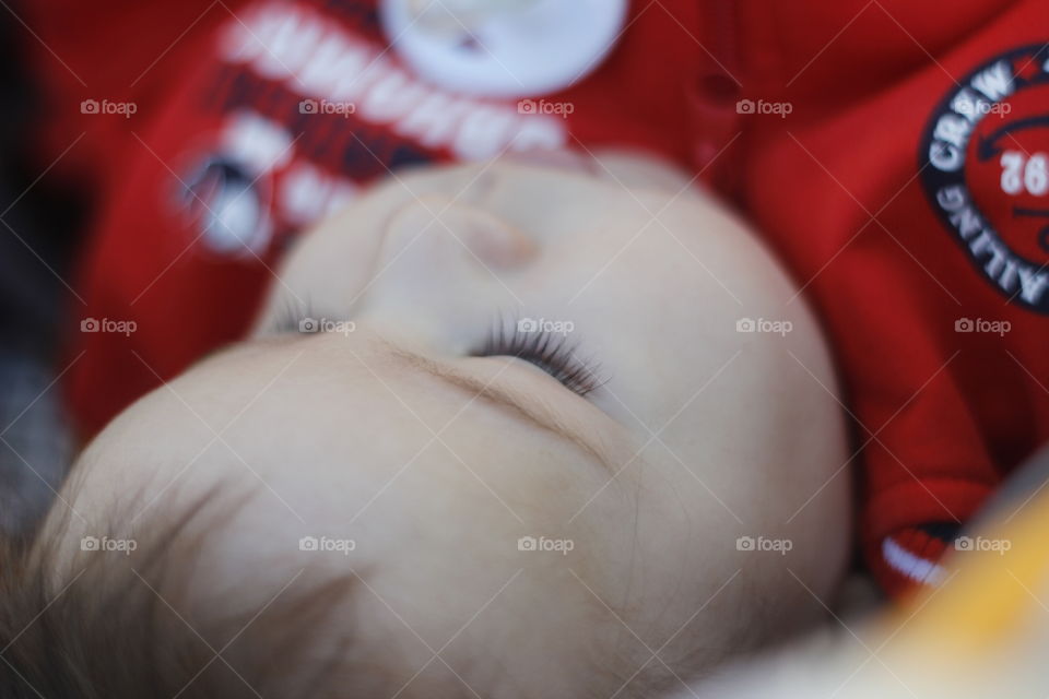 Close-up of baby boy face lying on bed