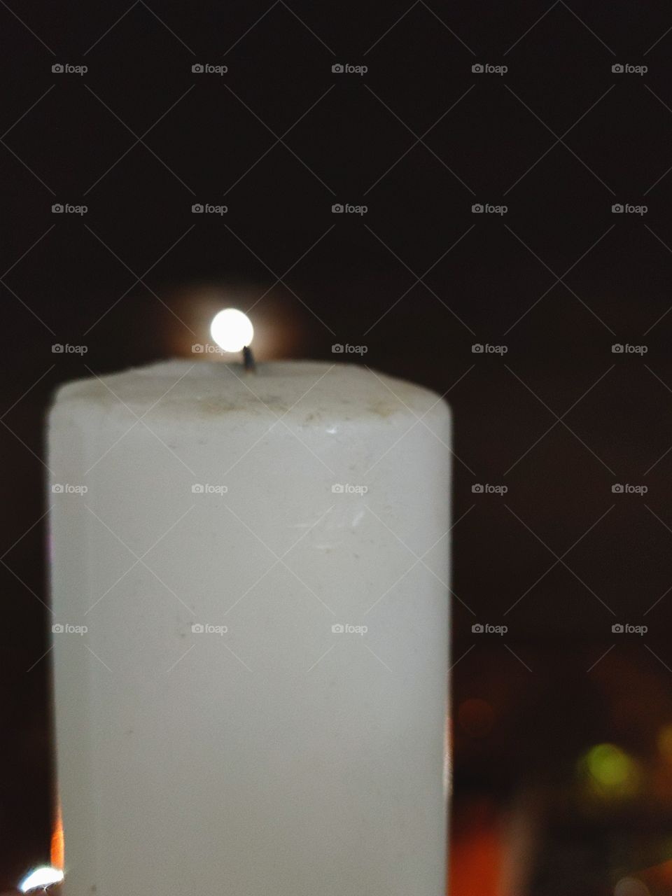 Night.  White candle.  The moon shines on the black tip of the candle wick
