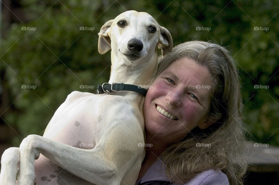 The proud owner of a whippet poses for the camera.