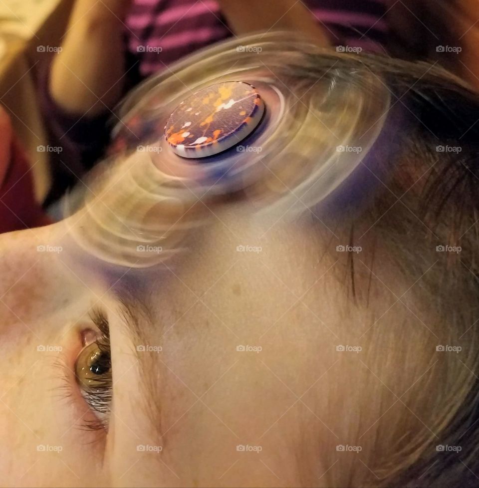 fidget spinner trick on boy's forehead