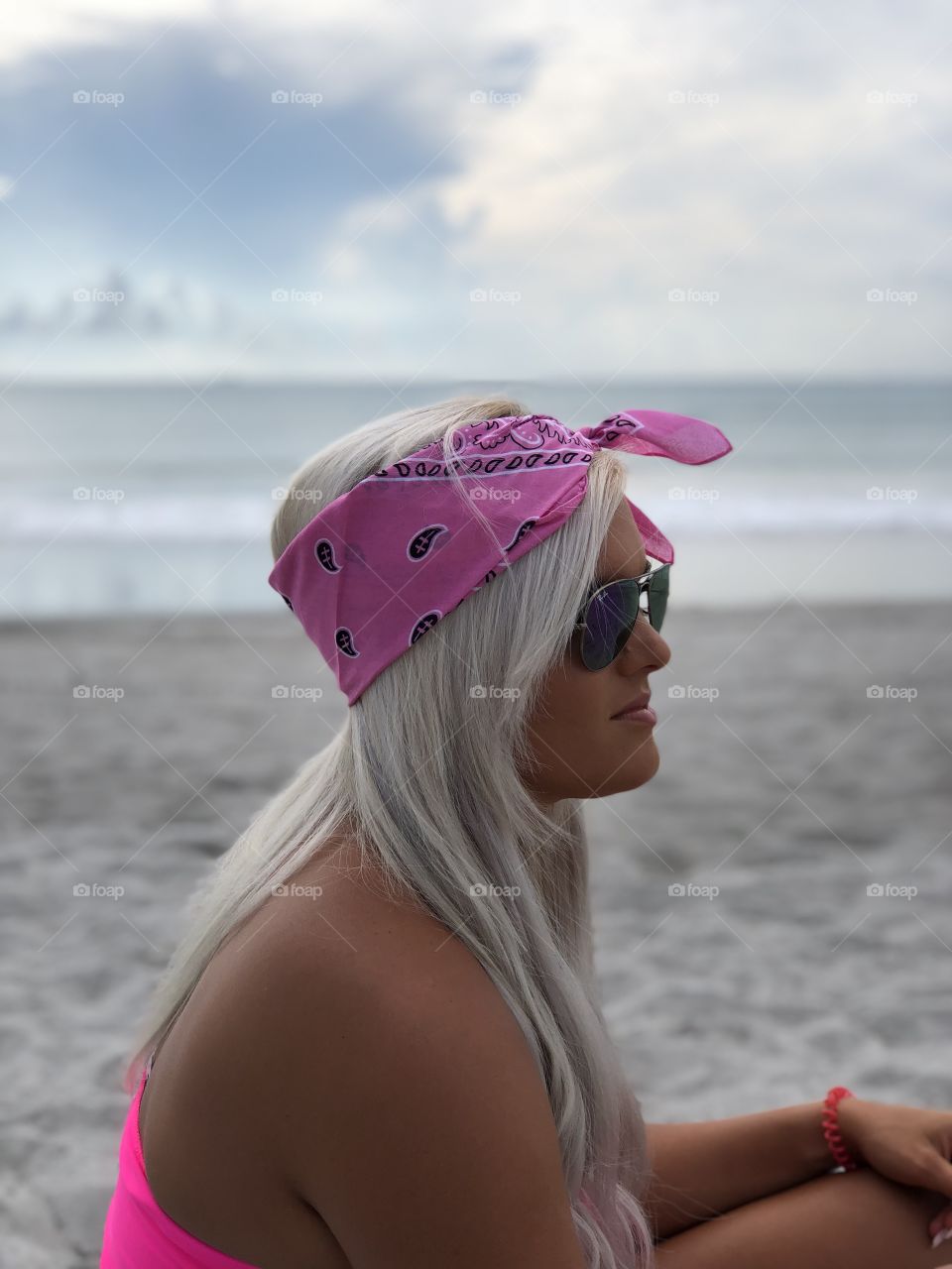 Blonde beach babe modeling a hot pink bandana. Ocean background in the Florida east coast 