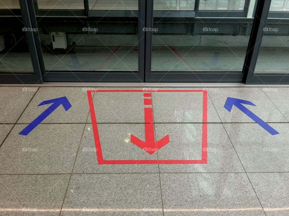 colored arrows on the entrance to a shuttle station showing where to queue