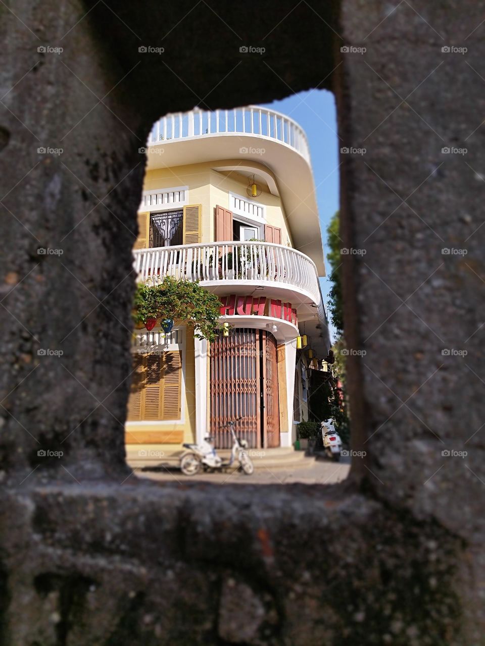 24th January 2025. 08:10am. Old town, Hoi an, Vietnam. Building portrait framed my a concrete post. Blue sky.